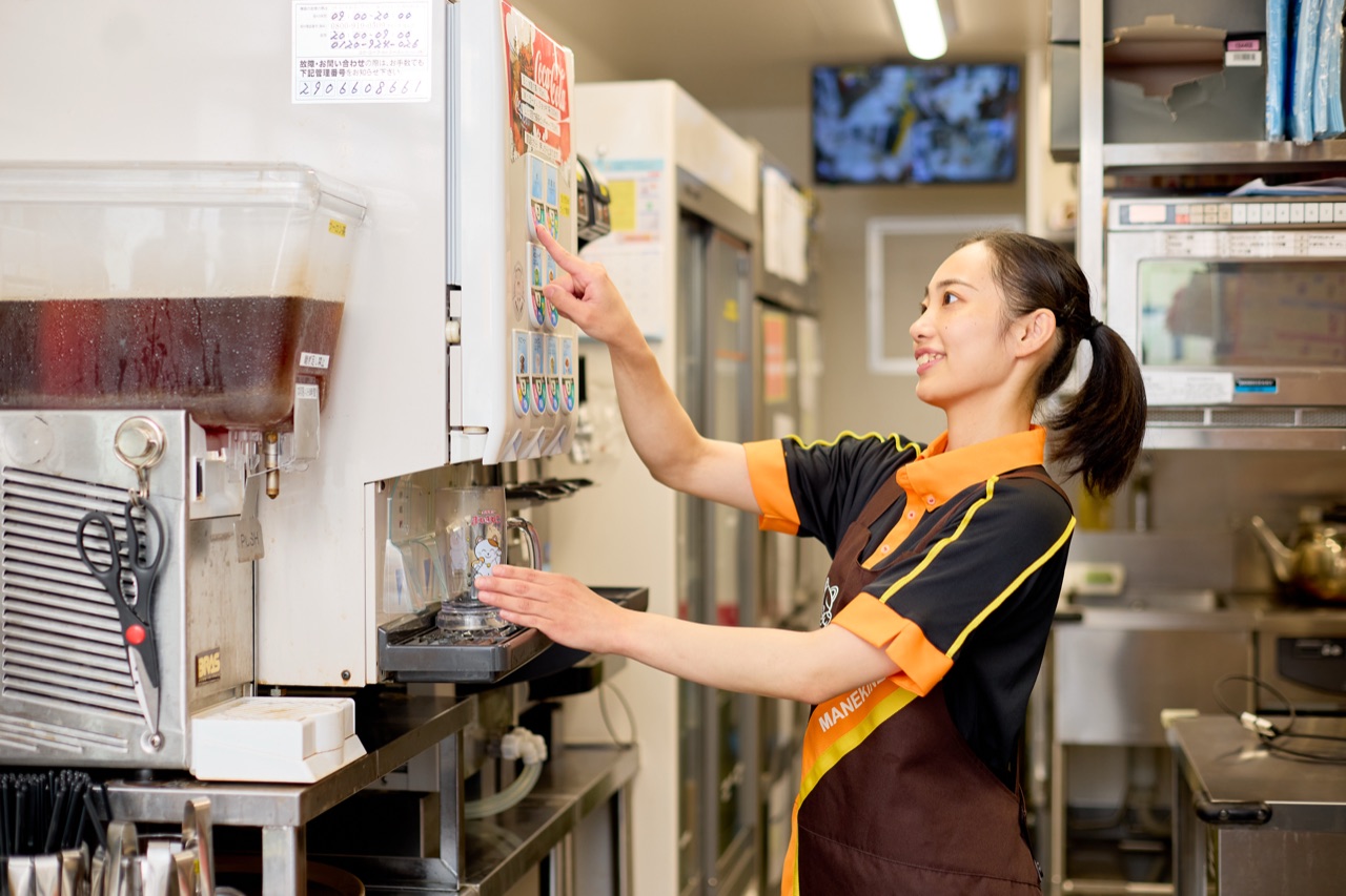 A staff member at the self-serve drink station
