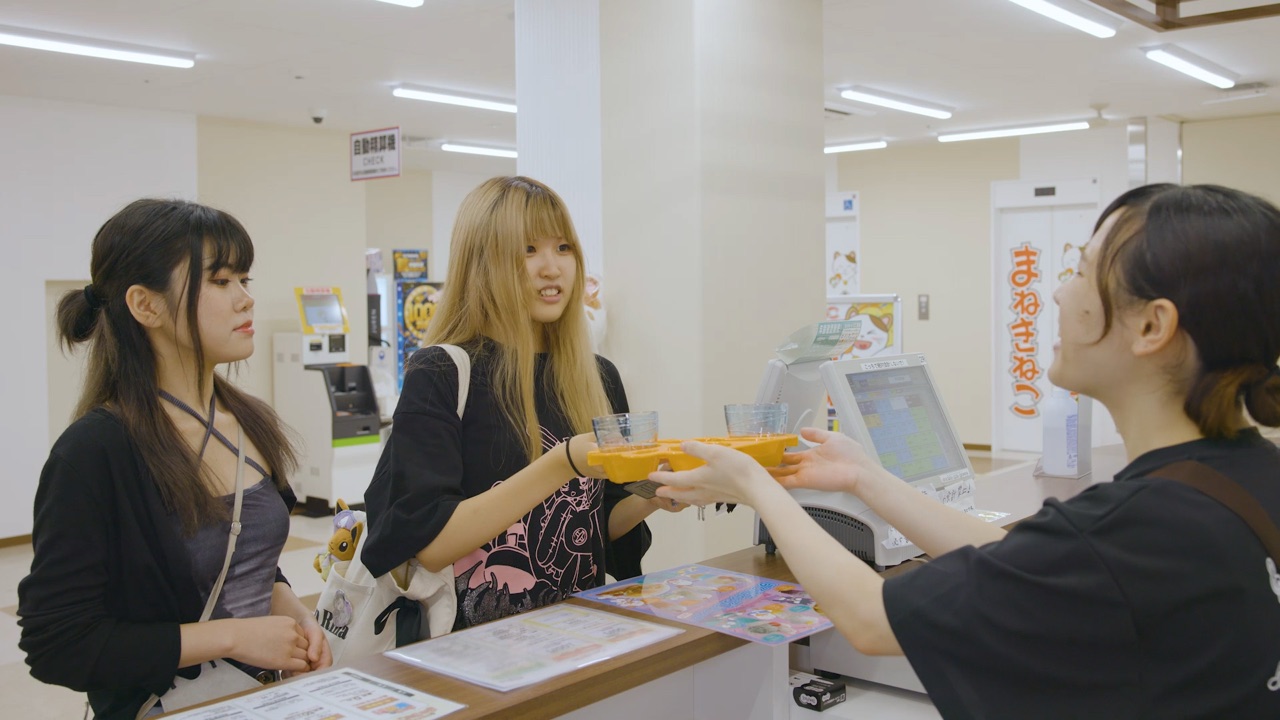 A staff member handing drinks to guests at the counter